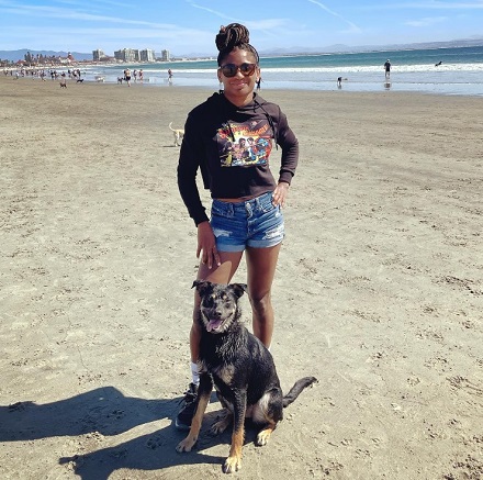 Angela Hill enjoying on beach with her dog